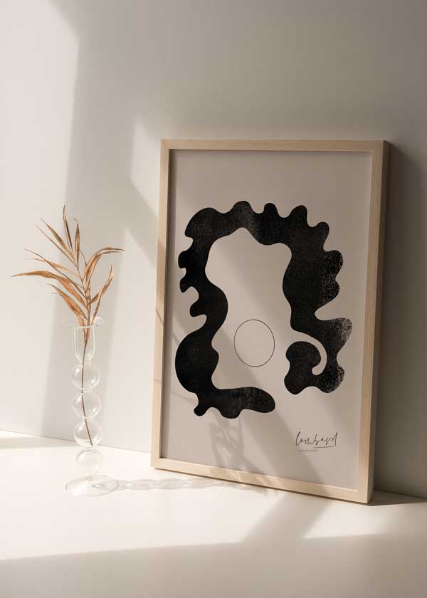 Cuadro minimalista y abstracto con figura en negro y círculo sobre fondo beige. Una obra abstracta y moderna