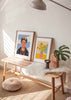 Cuadro de ilustración de Frida Kalho sobre con moño de flores sobre cielo azul de fondo. Una de las obras de Gigi Rosado - idea de decoración con cuadros