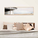 cuadro horizontal encima de la cama y fotográfico de playa con caseta y dos personas mirando el horizonte - kuadro
