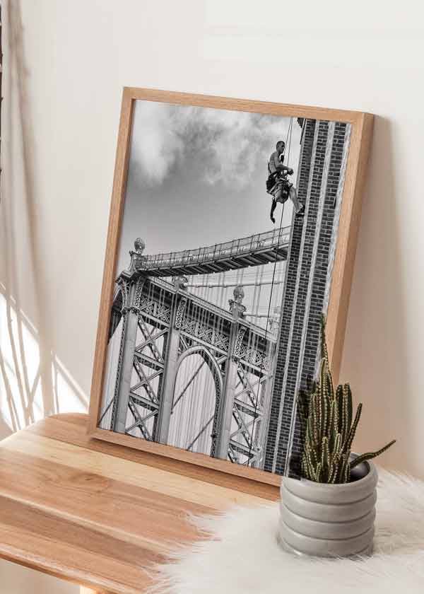 decoración con cuadros, ideas - lámina decorativa fotográfica en blanco y negro de obrero colgado sobre edificio de Brooklyn - kuadro